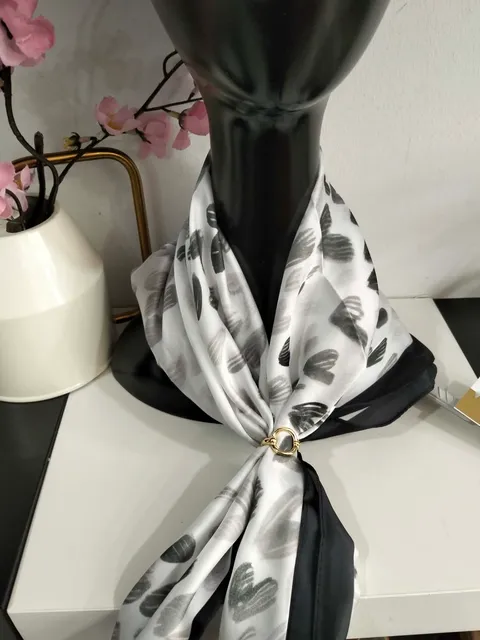 PAÑUELO DE CUELLO ESTAMPADO CON BROCHE DORADO DE TACTO SUAVE Y TEJIDO SATINADO M.PÑ-NGG 1 Pañuelo de cuello gris con estampado en negro sobre tejido satinado y broche dorado de remate