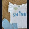 Conjunto niña leggins celeste con camiseta de volantes y estampado en relieve en el delantero