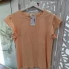 CAMISETA BÁSICA NARANJA SUAVE CON VOLANTES EN LAS MANGAS M.VOLA-NA 7 Camiseta naranja con volantes en las mangas, de cuello redondo y corte recto, en un tono naranja suave y liso