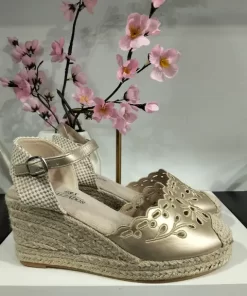 Cuña de esparto dorada con pala bordada y calada, pulsera al tobillo con hebilla y base de yute trenzado.