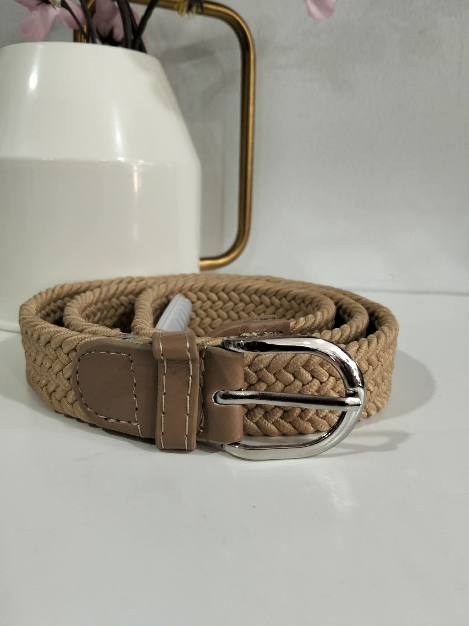 CINTURÓN TRENZADO ELÁSTICO EN COLOR BEIGE M.CIN-BE 1 Cinturón trenzado elástico beige enrollado, complemento infantil de la tienda Ana Hidalgo