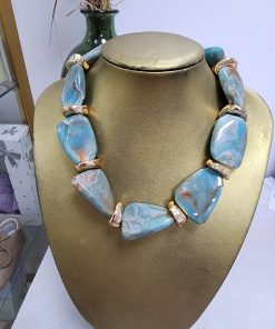 Collar de piedras azul con crema y beige claro, piezas ovaladas y alargadas y separadores dorados