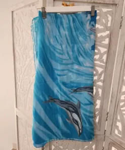 Falda pareo estampada azul con fondo marino, ondas en tonos celestes y dos delfines nadando en diagonal