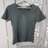 CAMISETA VERDE GRISÁCEO CON DETALLES DE BOTONES M.VG/BO 4 Camiseta verde con botones en tono verde grisáceo, manga corta y escote redondo con abertura