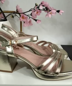 Zapato de tacón dorado de mujer con siete centímetros de altura y acabado metalizado en oro