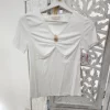 CAMISETA BLANCA CON FRUNCE Y DETALLE DECORATIVO M.YT-BLANCA 5 Camiseta blanca con frunce en el delantero, escote de pico, manga corta y aplique decorativo