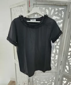 Camiseta negra con flores en relieve en el cuello y en las mangas