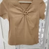 CAMISETA CAMEL CON BROCHE DORADO M.CM-CAMEL 6 Camiseta camel broche dorado con escote en pico y manga corta en tejido de algodón elástico