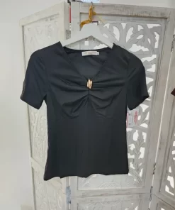 Camiseta negra con frunce frontal, escote en pico, manga corta y aplique decorativo