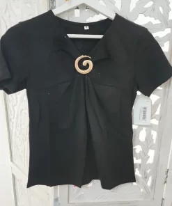 Camiseta negra broche dorado con escote en pico, manga corta y aplique decorativo en el delantero