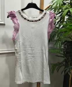 Camiseta blanca con volantes malva de encaje calado y pedrería en el escote redondo