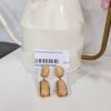 PENDIENTES DE PIEDRAS BEIGE M.PO/B 5 Pendientes piedra ovalada beige rematados en dorado, con tuerca a presión y forma alargada