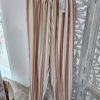 Pantalón bombacho rojo granate con rayas verticales en beige y marrón y cintura elástica ajustable