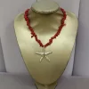 Collar con estrella de mar dorada como pieza central y piedras rojas alrededor