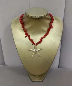 Collar con estrella de mar dorada como pieza central y piedras rojas alrededor