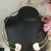 Collar doble aro nacarado con estructura dorada y dos piezas circulares en tono marfil