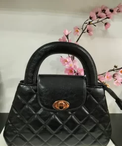 Bolso de mano acolchado negro con aplique dorado en el cierre y asa para colgar